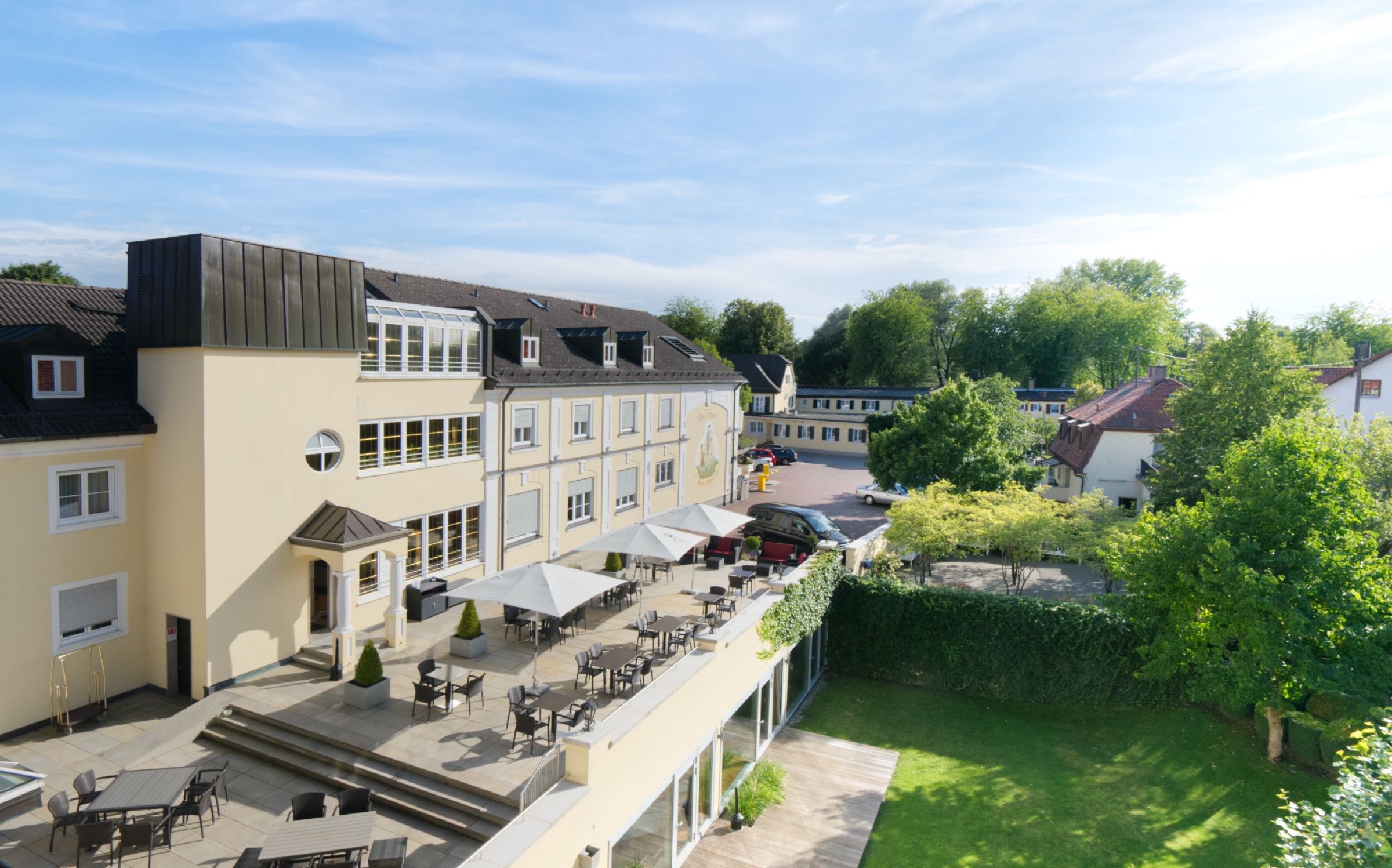Hotel mit Garten und Terrasse von oben an einem Sommertag